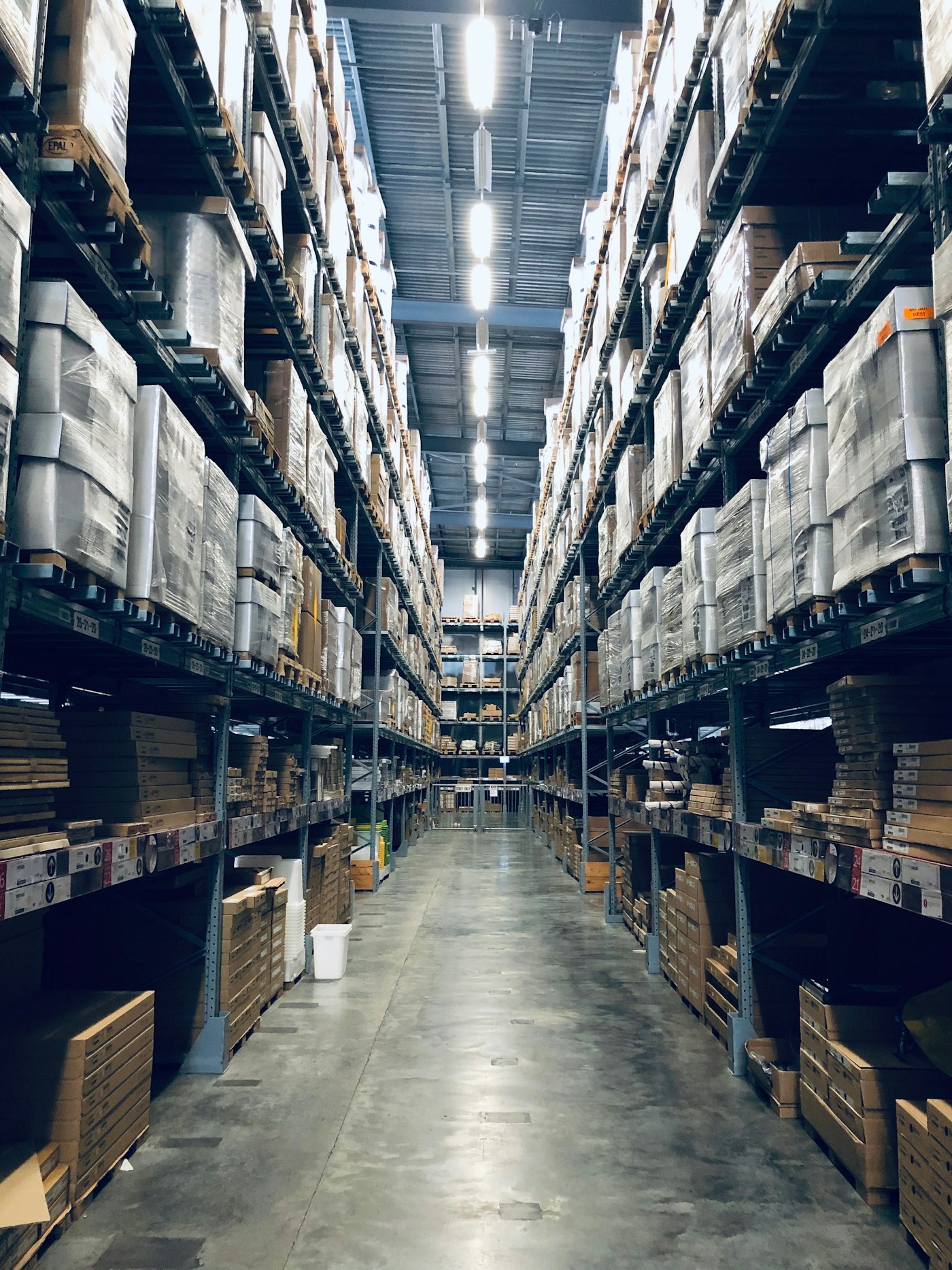 A storeroom aisle of stock on high shelves.